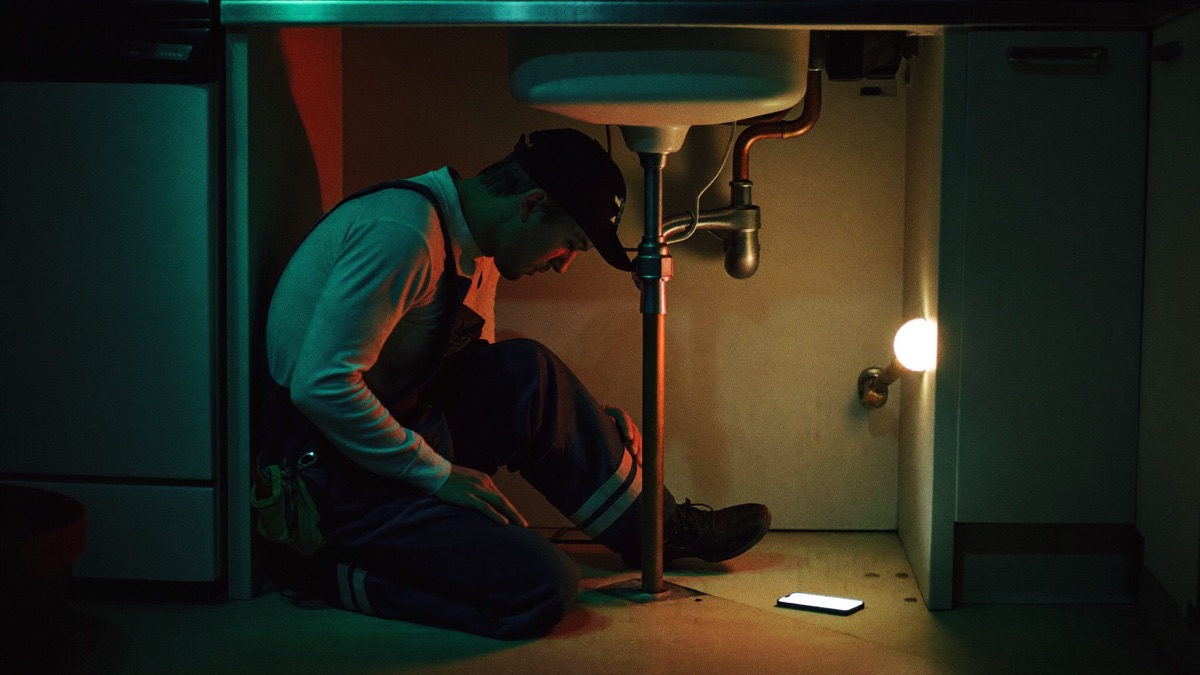 Plumber at work while the AI receptionist answers his phone